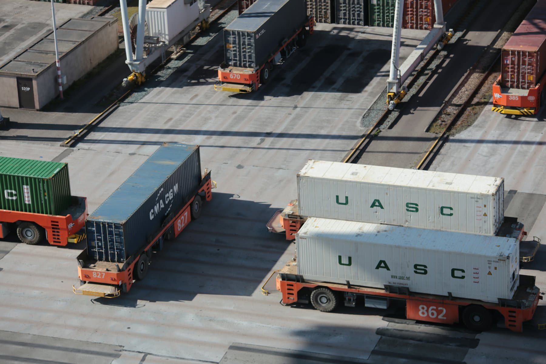 Container handlers moving freight across a loading terminal