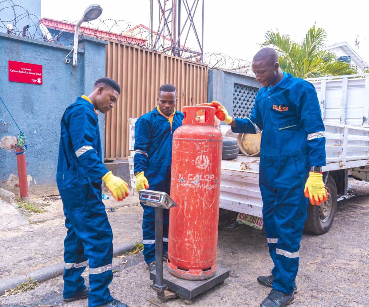 A Suez Gas crew weighing a cylinder at the point of delivery